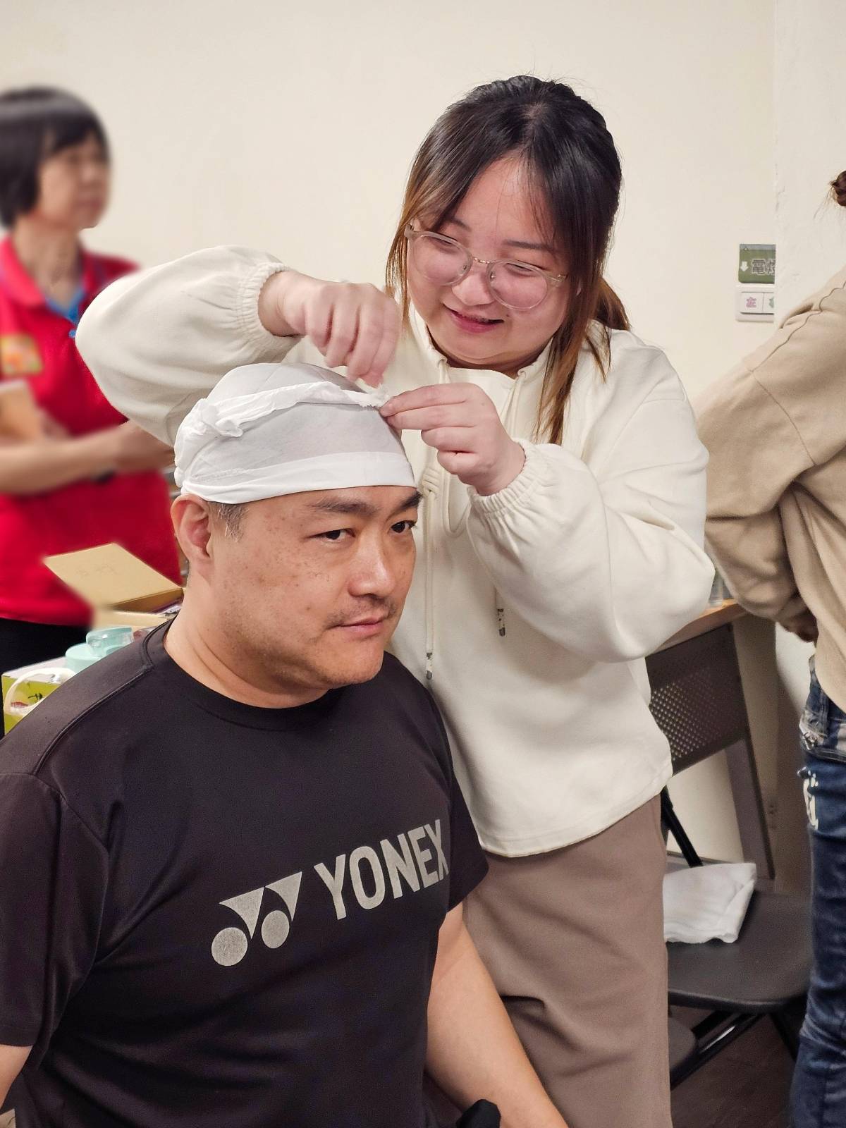 學員使用三角巾練習頭部包紮